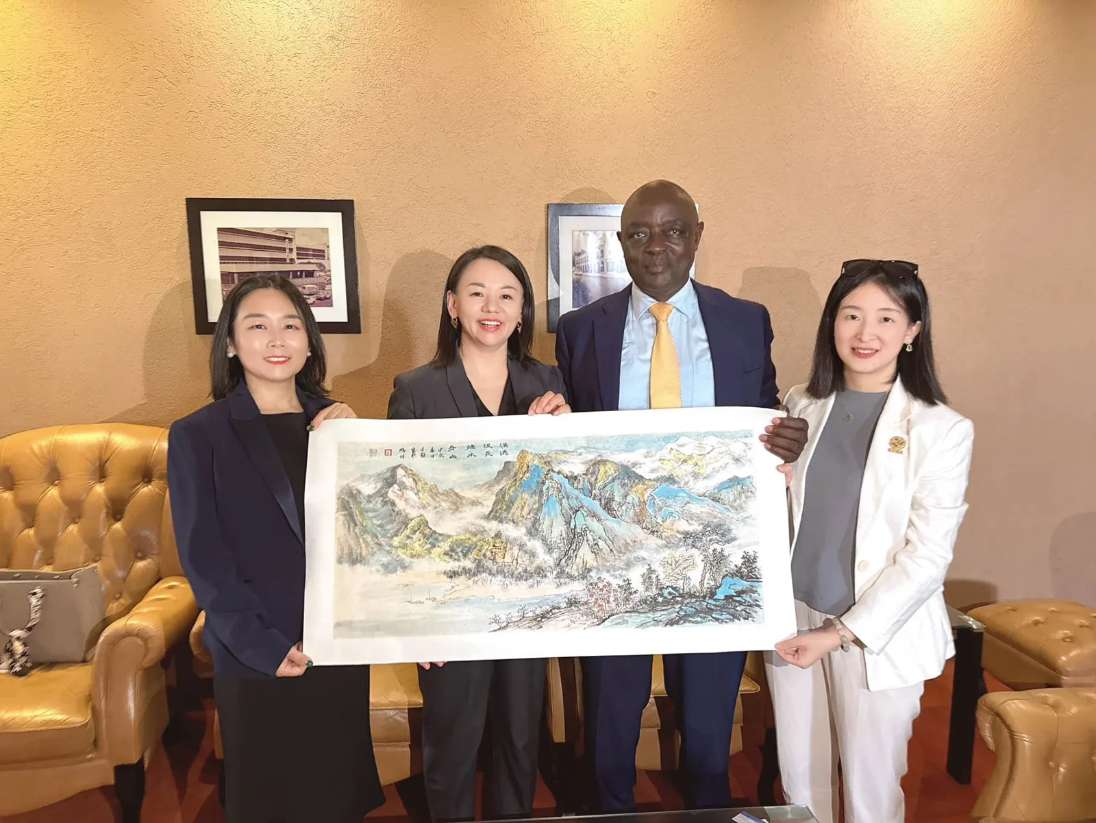 GFWE representatives with Hon. Vincent Bamulangaki Ssempijja, Senior Presidential Advisor of Uganda, presenting a traditional Chinese landscape painting